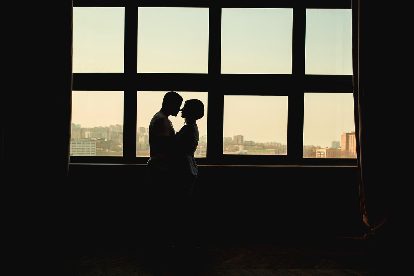 Liebesleben in Coronazeiten: Paar umarmt sich hinter Fensterscheiben