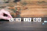 Eine Frau legt mit Bauklötzen die Empfehlung "let it go"