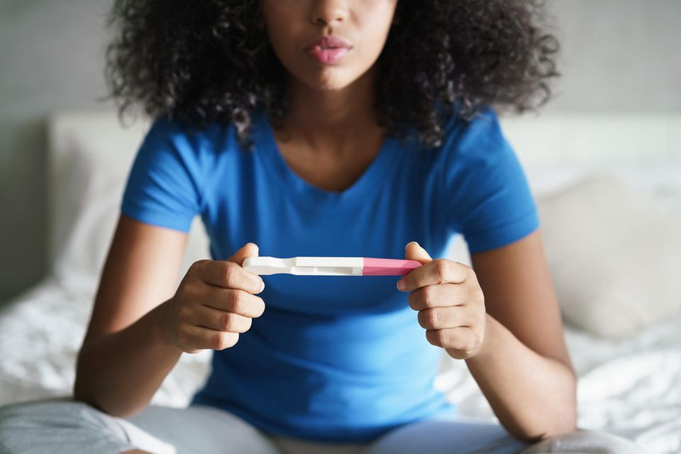 Ungewollte Schwangerschaft: Frau mit Schwangerschaftstest