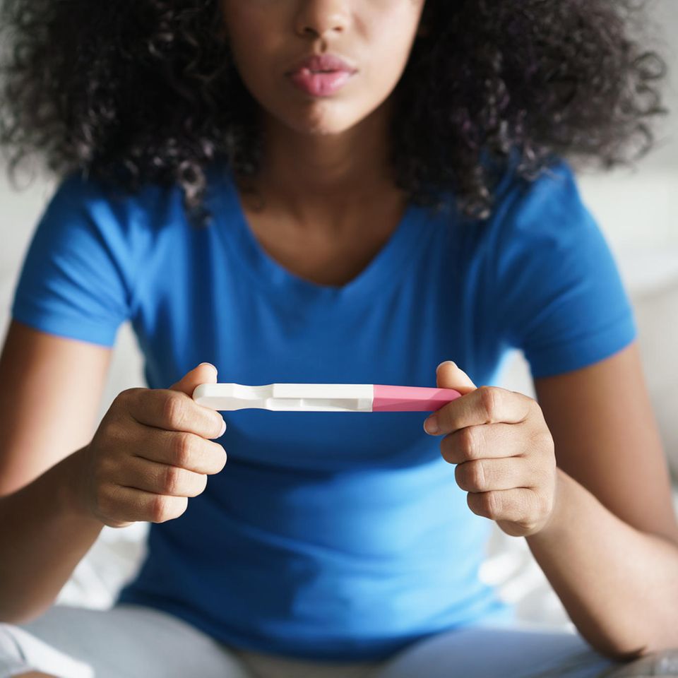 Ungewollte Schwangerschaft: Frau mit Schwangerschaftstest