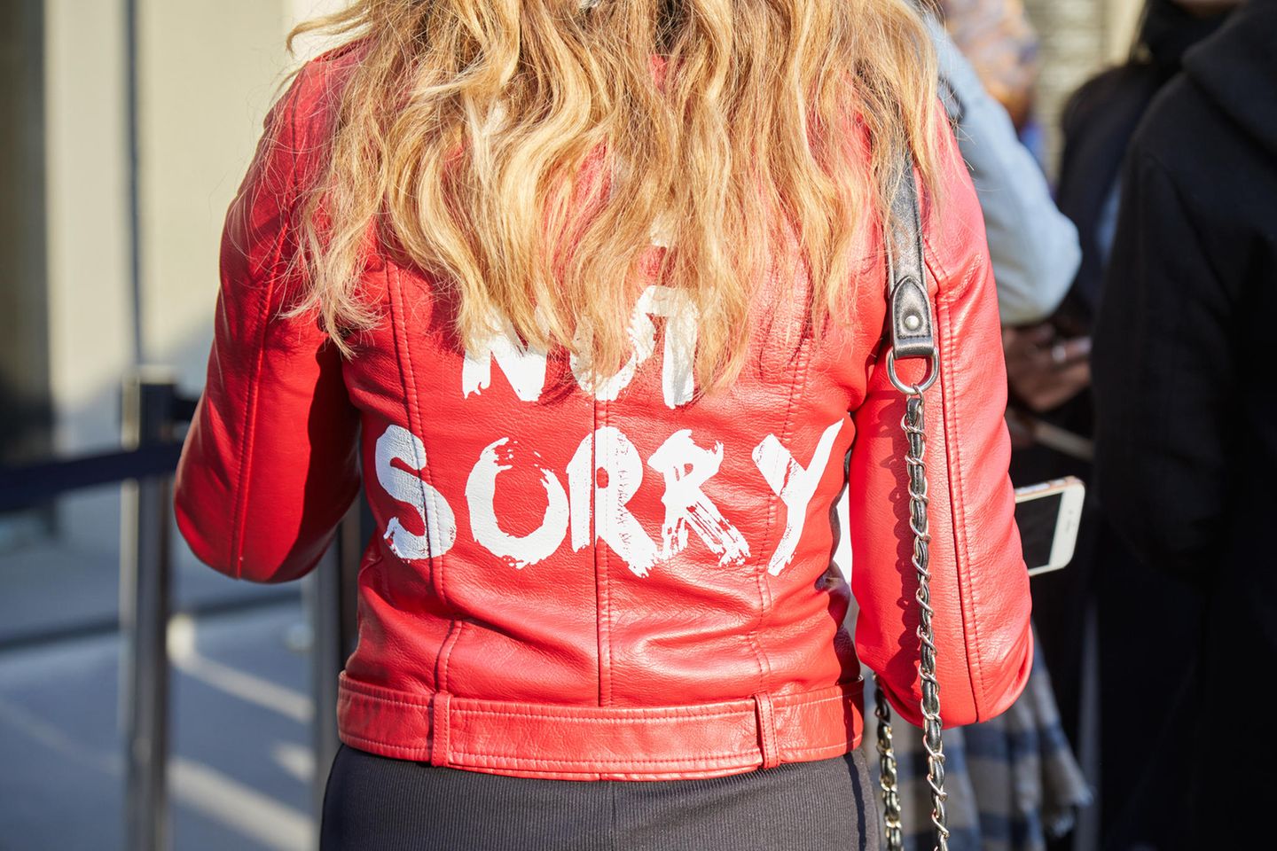 Nicht entschuldigen: Eine Frau trägt eine Jacke mit der Aufschrift "not sorry"