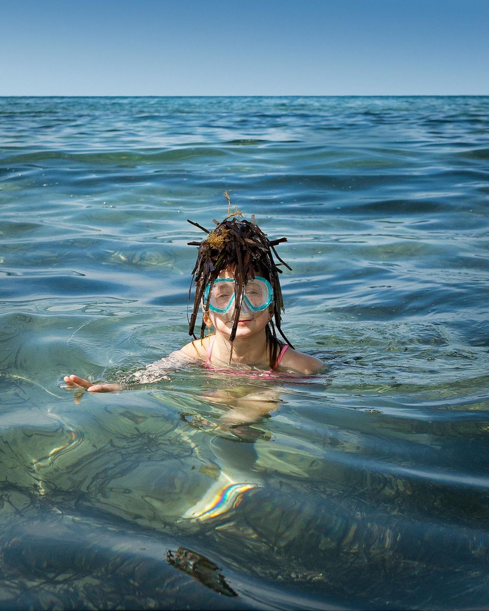 Zypern: Mädchen im Wasser mit Algen auf dem Kopf