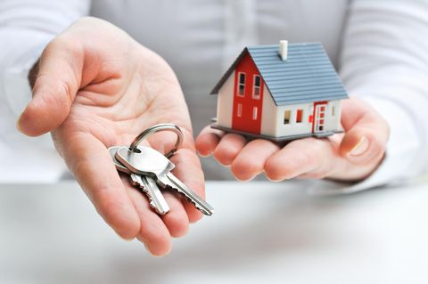 Immobillienmakler miit Schlüssel und Haus