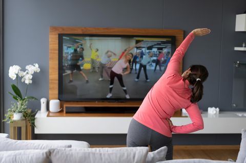 Home-Workouts machen keinen Spaß: Frau macht Aerobic vor dem Fernseher
