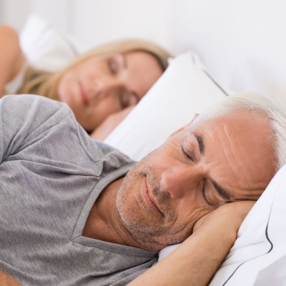 Schlafstörungen im Alter: Älterer Mann und ältere Frau schlafen