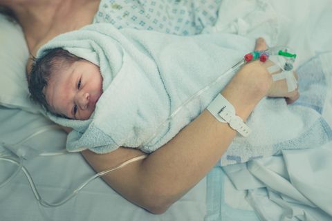 Corona aktuell: Eine Frau im Krankenhaus mit Baby im Arm