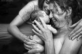 Geburtsfotos 2021: Frau hält Baby vorm Gesicht