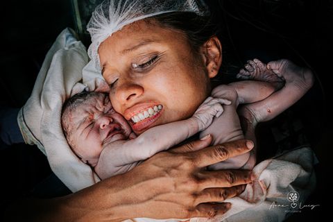 Geburtsfotos: Frau hält Neugeborenes