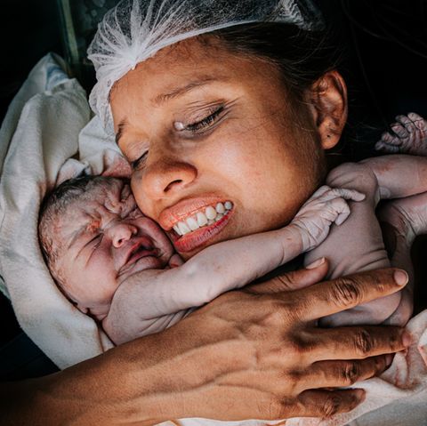 Geburtsfotos: Frau hält Neugeborenes