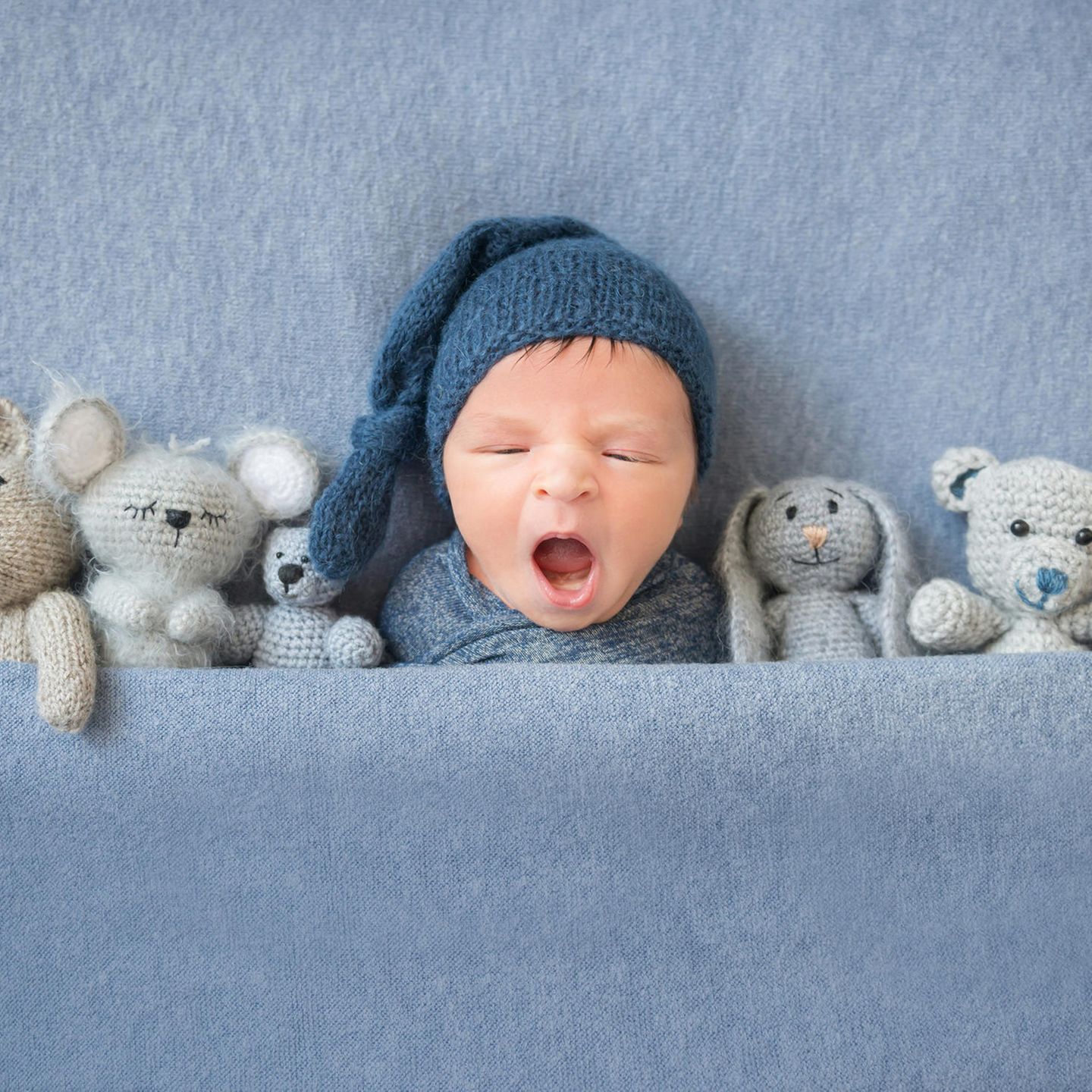Liebevolle Babynamen: Baby mit Kuscheltieren