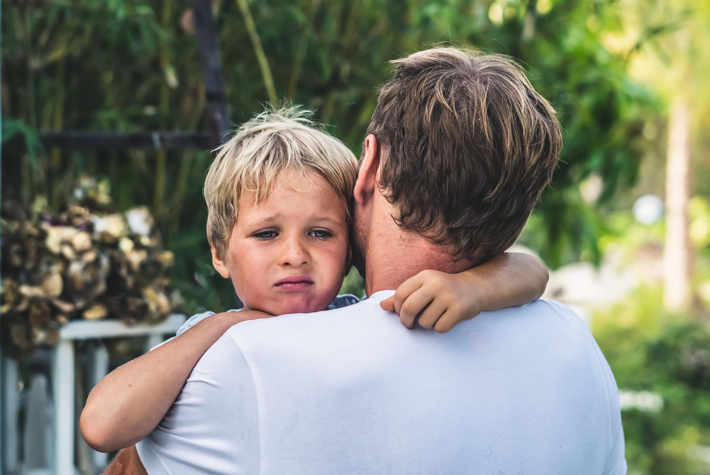Dinge, die toxische Eltern tun: Trauriges Kind auf dem Arm vom Papa