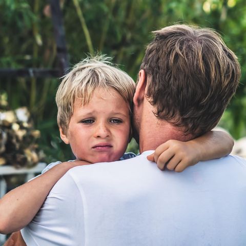 Dinge, die toxische Eltern tun: Trauriges Kind auf dem Arm vom Papa