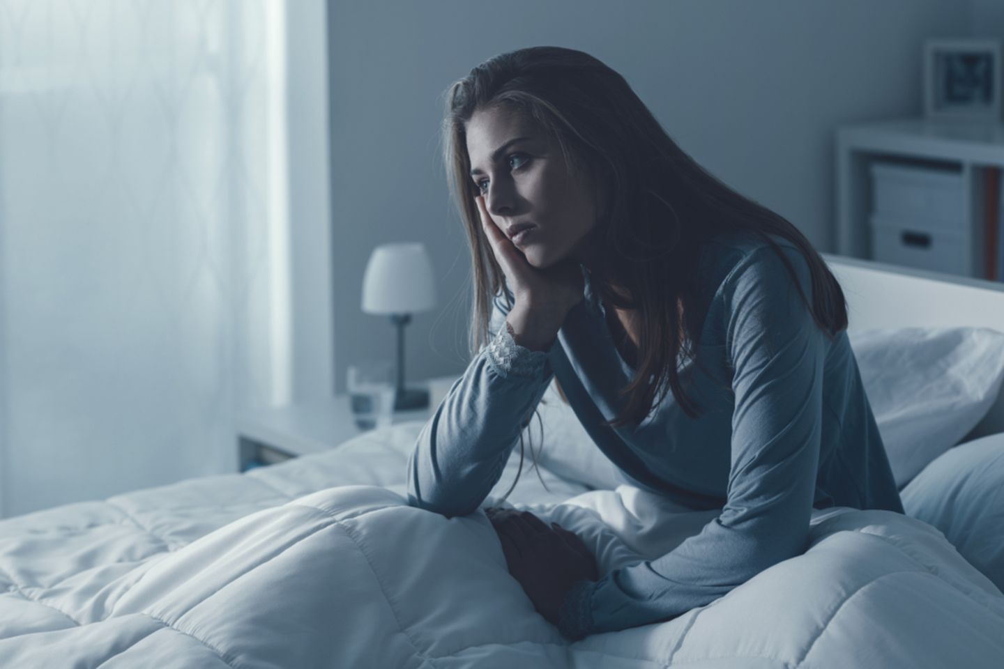 Schlafmangel: Frau sitzt im Bett
