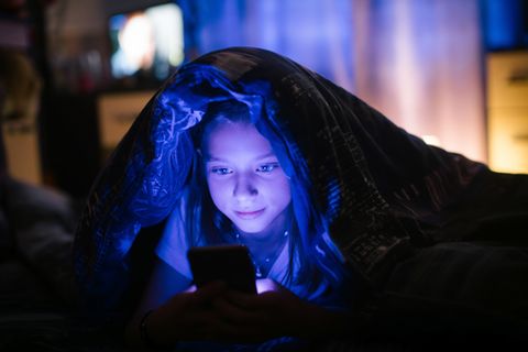 Smartphones: Mädchen im Bett mit Handy