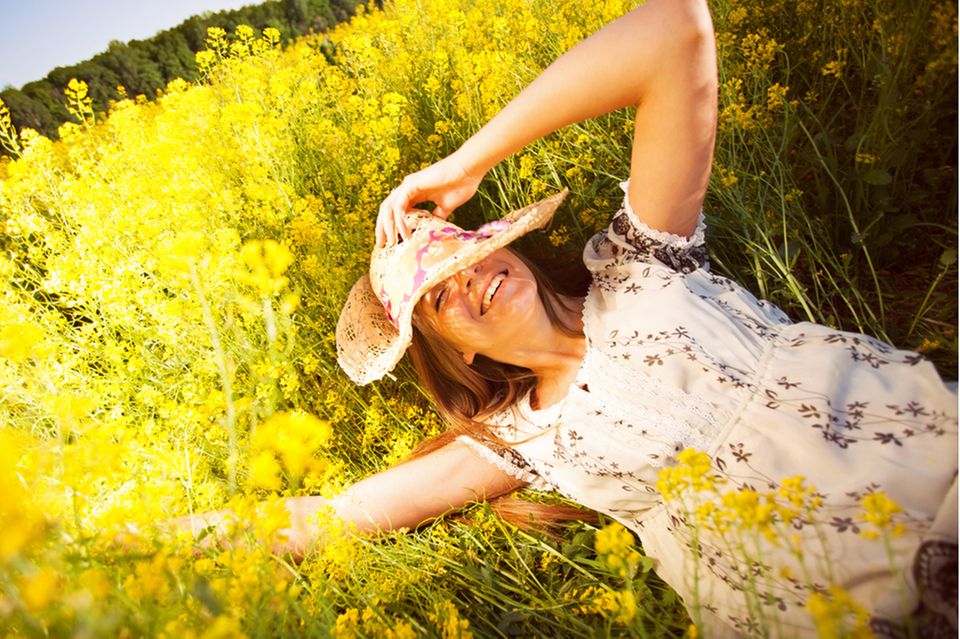 Positives Mindset: Frau liegt auf einer Sommerwiese