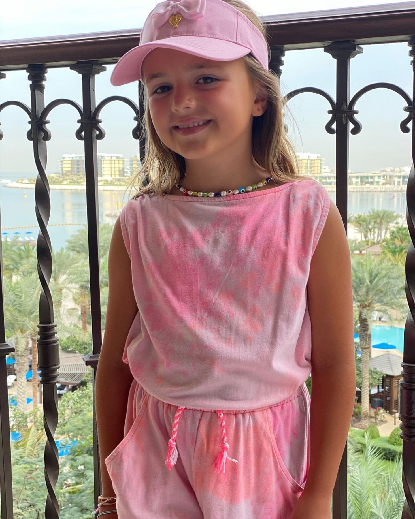 Sophia, die ältere Tochter von Tamara Ecclestone und Jay Rutland, posiert in einem coolen Batik-Zweiteiler und mit rosafarbener Visoren-Cap und cooler Kette auf dem Balkon. Im Hintergrund ist Dubai zu erkennen, wo Familie Ecclestone gerade einen "verlängerten Urlaub" macht. 