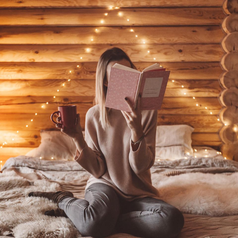 Psychologie: Eine Frau sitzt im Bett und liest