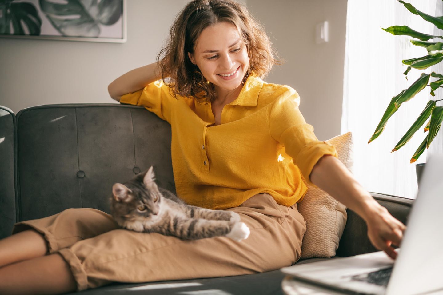 Selbstfürsorge: Frau mit Katze auf dem Sofa