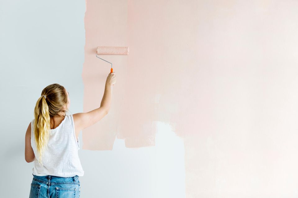 Wohnzimmer streichen: Mit diesen Tipps gelingt es, junge Frau, rosa Wand