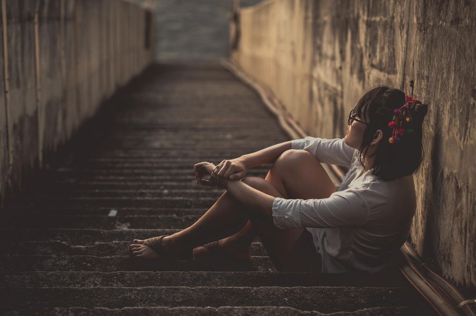 Psychologie: Eine traurige Frau auf einer Treppe