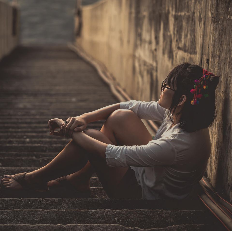 Psychologie: Eine traurige Frau auf einer Treppe