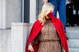 Königin Máxima schafft es, eine Kombi, die sonst fast zu sexy wäre, elegant aussehen zu lassen: Sie trägt ein leichtes Midi-Dress mit Leo-Muster, das an der Taille betont. Darüber hat sie sich einen knallroten Cape-Mantel (beides von Natan Couture) geworfen und ihre roten Pumps perfekt abgestimmt. 