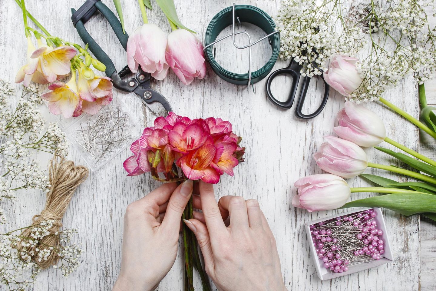 Frühlingsdeko basteln: Frau bastelt mit Blumen