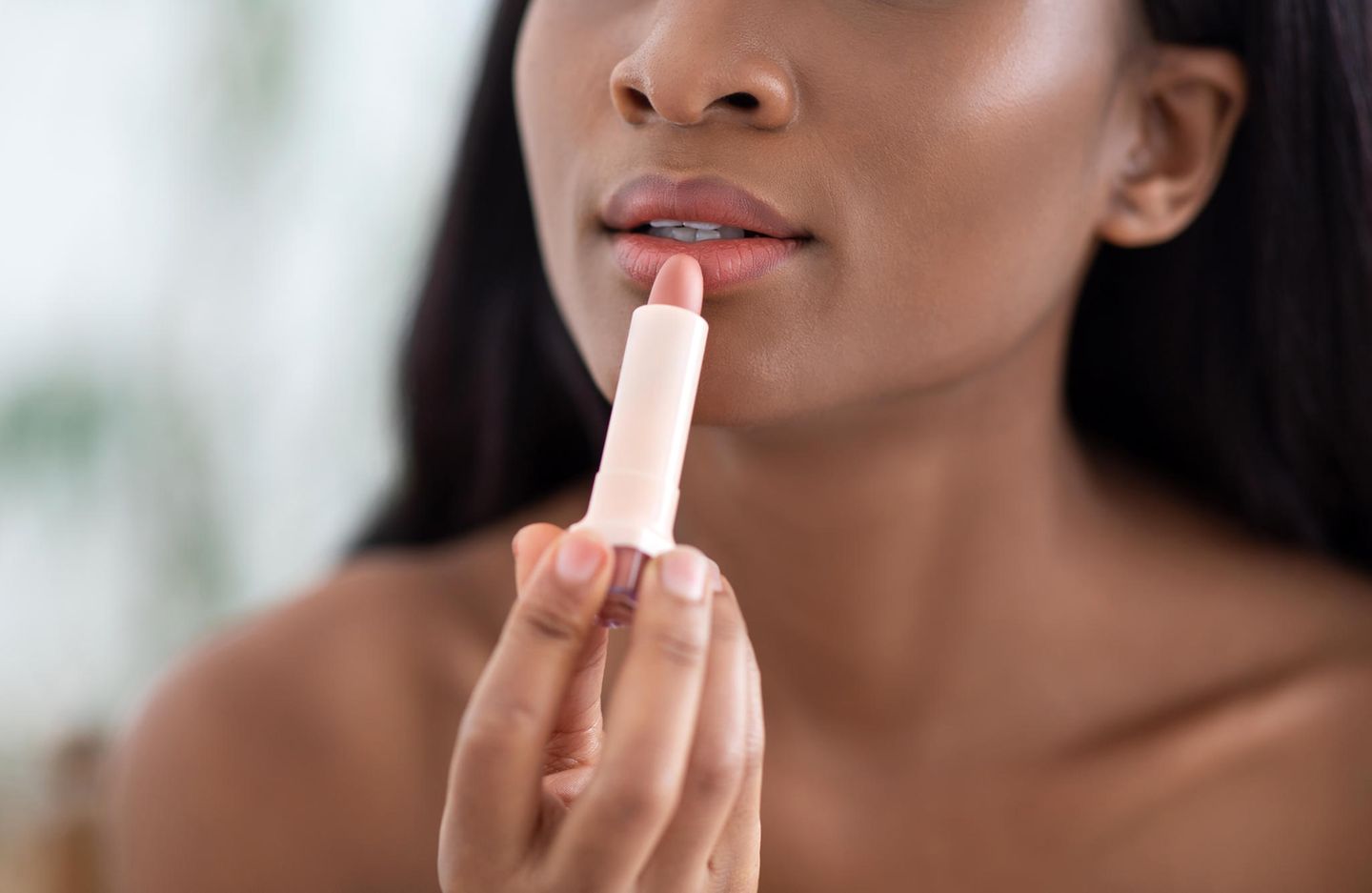 Lippenstift matt: 3 Produkte für jeden Hautton, eine junge Frau schminkt sich die Lippen