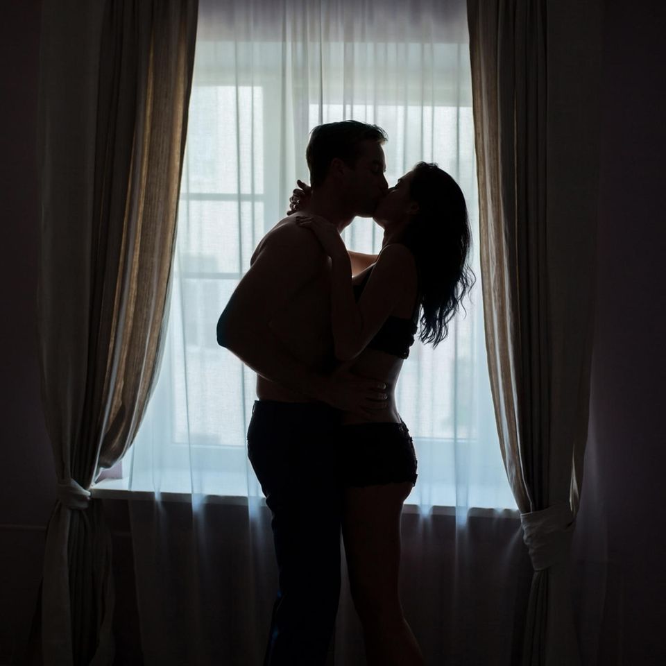 Sex im Stehen: Mann und Frau küssen sich eng umschlungen