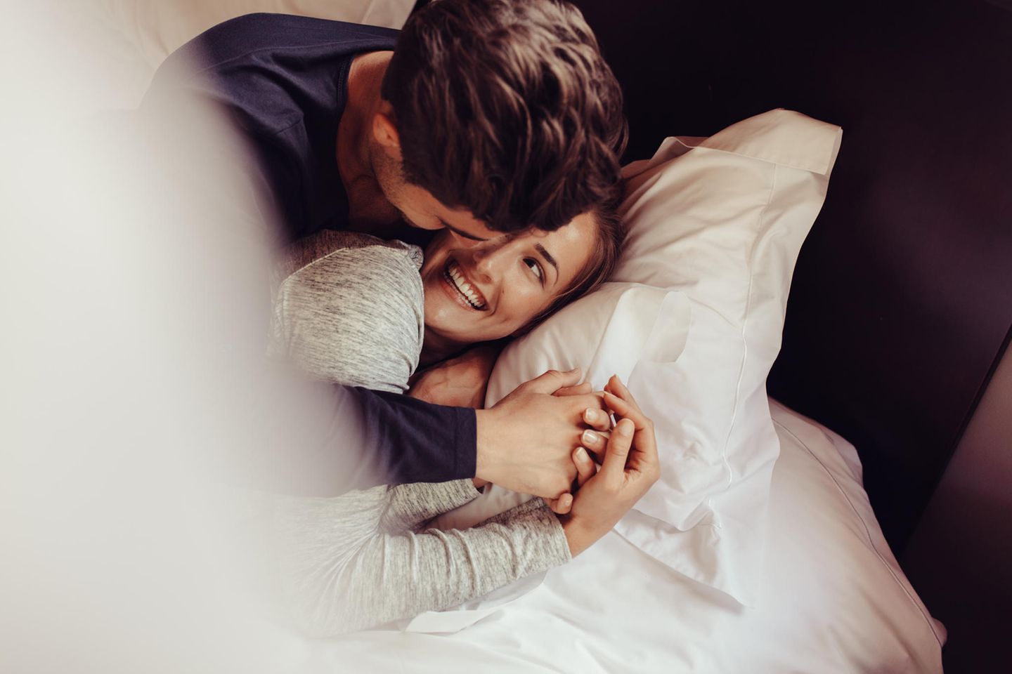 Swaddling: Mann und Frau kuscheln im Bett