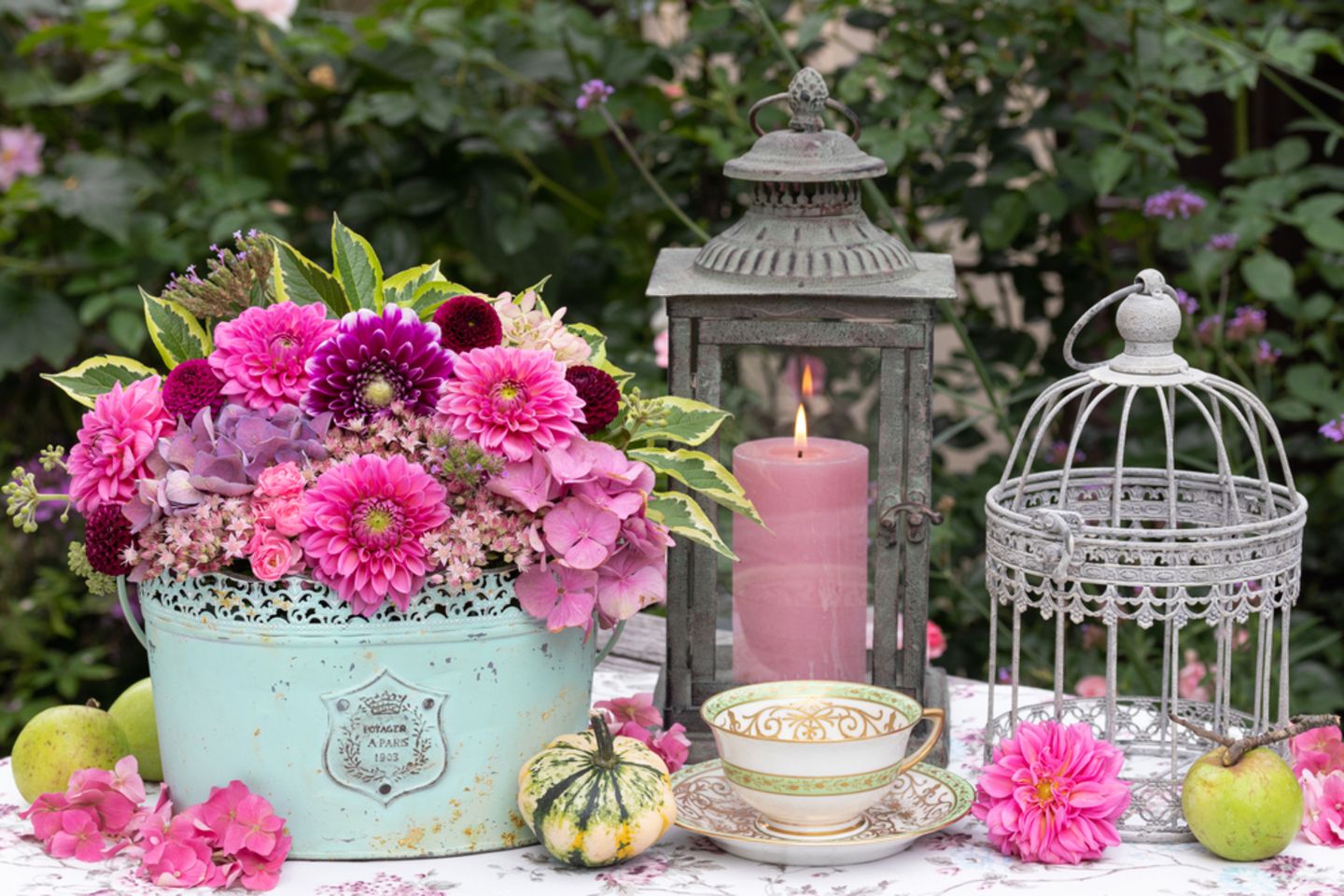 Garten dekorieren: Blumen und Windlicht auf einem Gartentisch