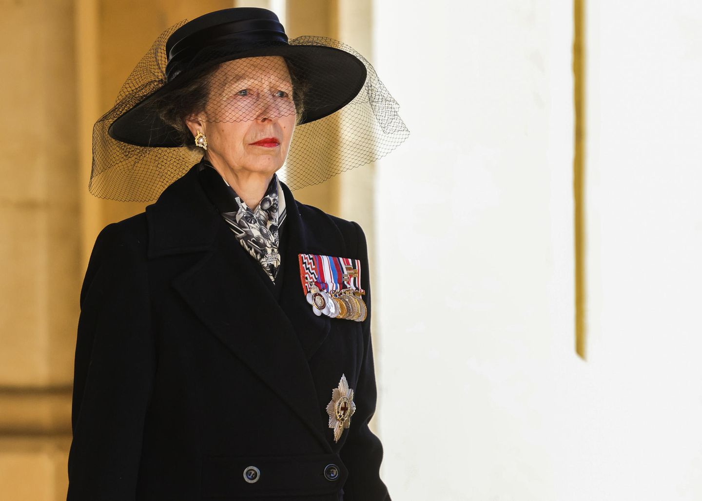 Prinzessin Anne nimmt als einzige Frau an der royalen Prozession teil. An ihrem Mantel stecken einige Militärabzeichen, an ihren Ohren funkeln Perlenohrringe, die ein Geschenk von Prinz Philip und der Queen waren. Sie trug sie unter anderem zu ihrer zweiten Hochzeit mit Sir Timothy Laurence. 