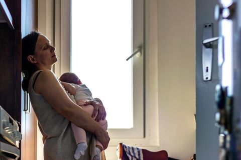 Familien als Stress-Hotspot der Nation: Erschöpfte Frau mit Baby auf dem Arm