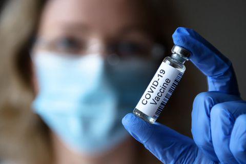 Corona aktuell: Frau mit Impfstoff in der Hand