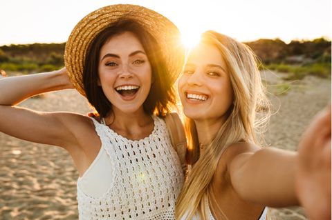 Optimismus: Zwei Frauen lachen in die Kamera.