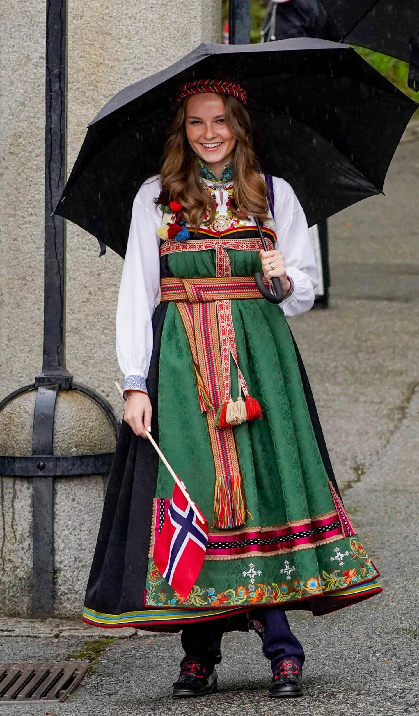 Am 17. Mai feiert Norwegen seinen Nationalfeiertag, wobei die Feier in diesem Jahr aufgrund der Pandemie kleiner ausfällt. Doch die Outfits der norwegischen Königsfamilie sind mindestens so opulent wie die Jahre zuvor. Besonders hübsch anzusehen ist das Kleid der 17-jährigen Royal. Die Robe trägt den Namen "Bunad" und ist ein Geschenk von ihren Großeltern Königin Sonja und König Harald. Das traditionelle Kleidungsstück stammt aus Aust-Telemark und erinnert an die Trachten, die schon um das Jahr 1810 von den norwegischen Frauen getragen wurden.