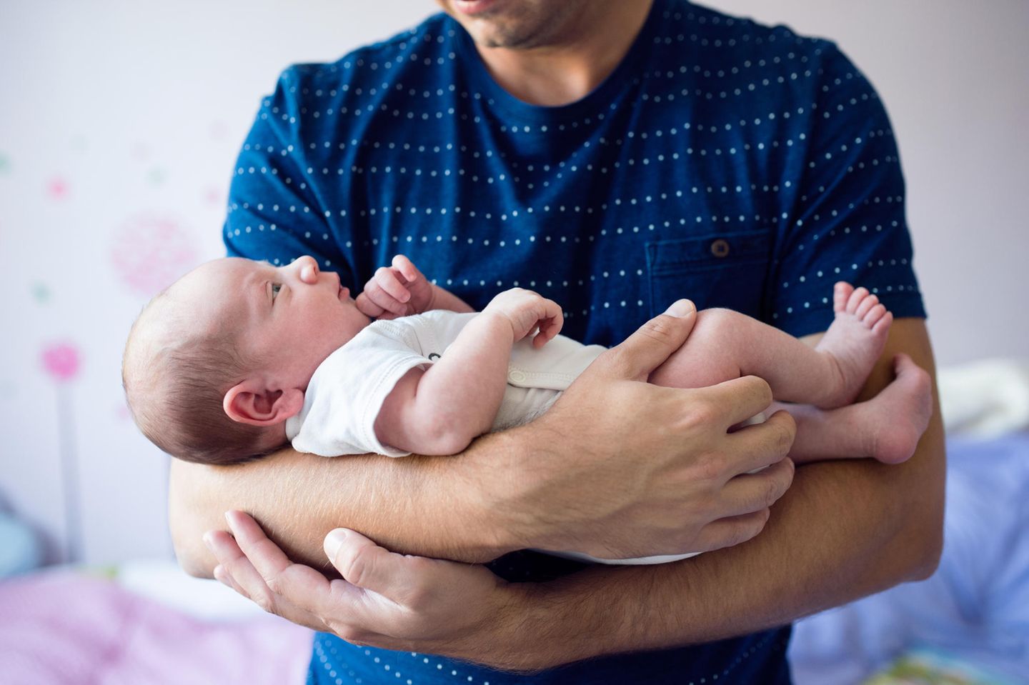 Kuckuckskind: Mann hält Baby im Arm