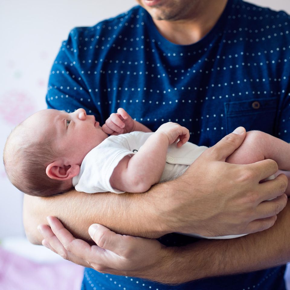 Kuckuckskind: Mann hält Baby im Arm