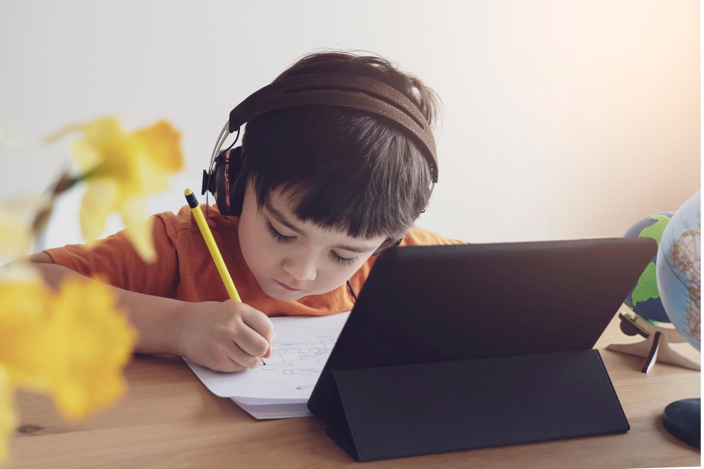 Schüer:innen erzählen: Junge macht Hausaufgaben vor Laptop