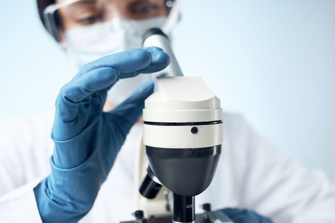 Corona aktuell: Medizinerin mit Mikroskop