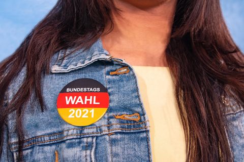 Corona aktuell: Frau mit Bundestags-Wahl-Button an der Jacke
