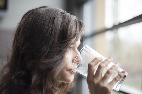 Trockener Mund: Frau trinkt Glas Wasser