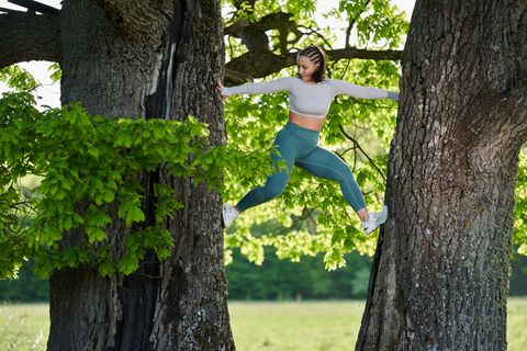 Natural Movement: Frau klettert Baum hoch