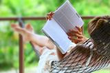 Horoskop: Eine Frau liegt in der Hängematte und liest