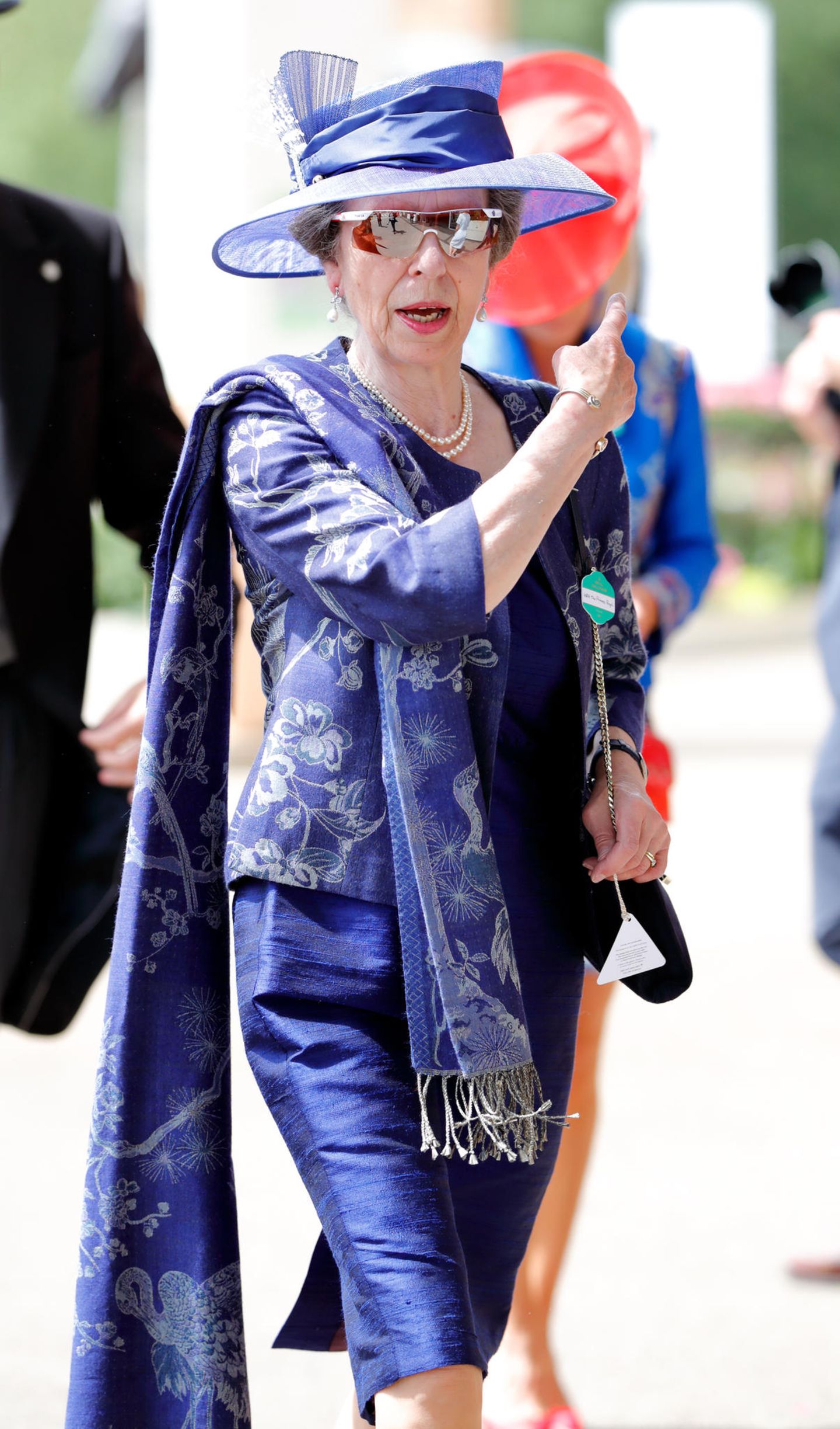 Prinzessin Anne setzt auf royales Blau und wählt ein schmal geschnittenes Kostüm mit Applikationen und Stola. 