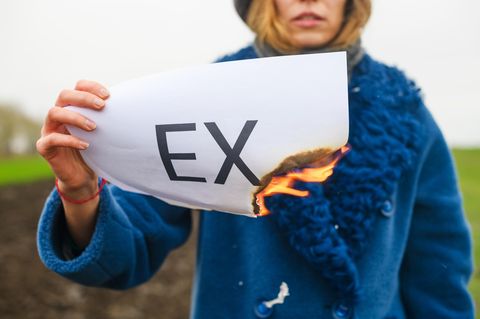 Ex-Partner des Partners: Frau hält brennenden Zettel beschriftet mit "Ex" in der Hand