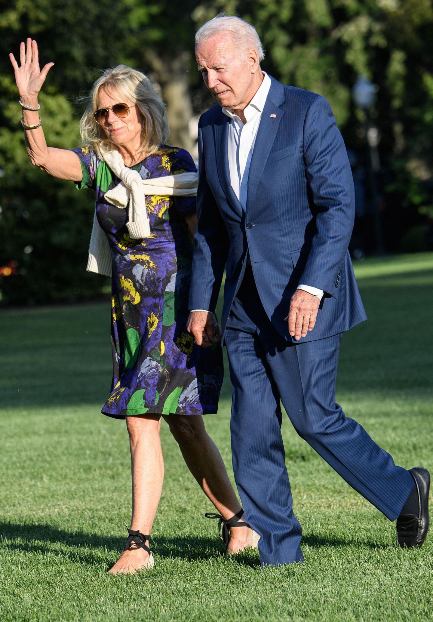 First Lady Dr. Jill Biden hat ein Händchen für Mode. Das beweist sie mal wieder bei der Ankunft im Weißen Haus. Sie kombiniert ein dunkelblaues Midikleid mit Flower-Print zu sommerlichen Wedges mit Schnürbändern. Diese Schuhe sind übrigens absolute Must-haves für den Sommer! Die coole Fliegerbrille und der Pullover um ihre Schultern geben ihrem Outfit eine gewisse Lässigkeit.