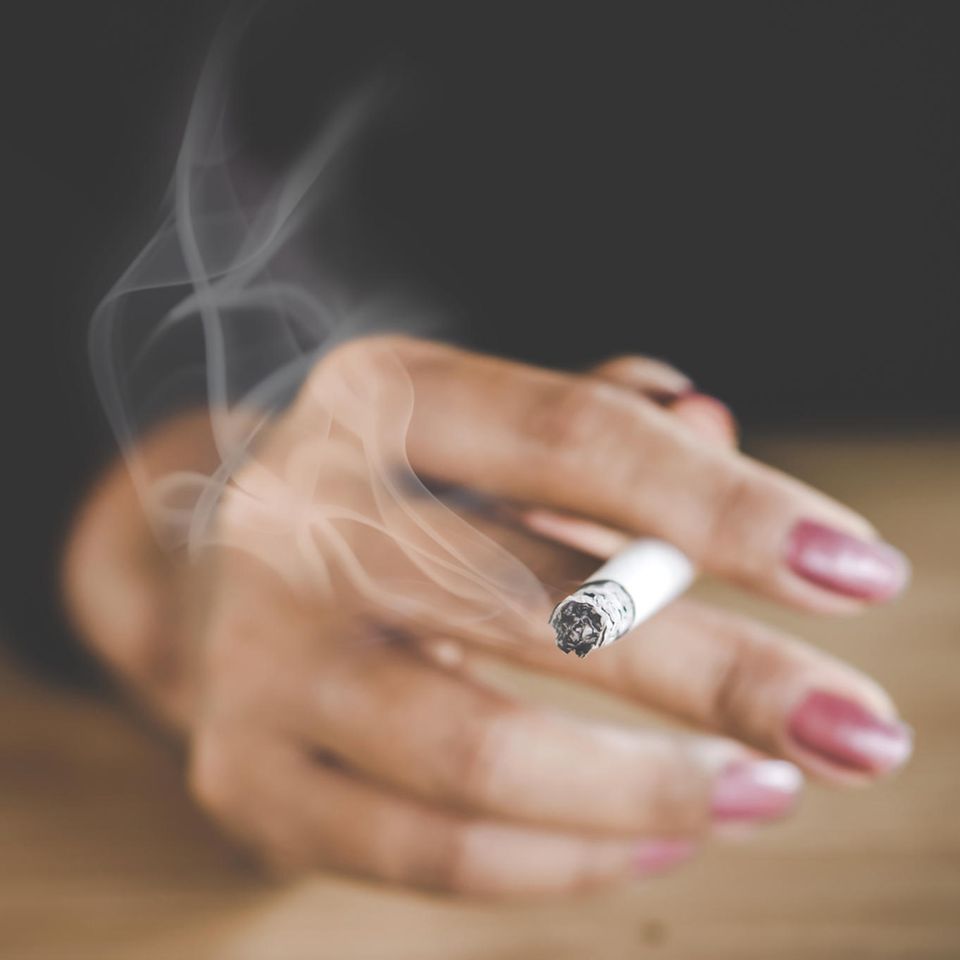 Rauchen aufhören: Frauenhand mit Zigarette
