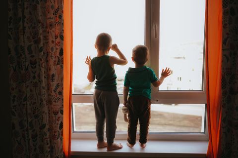 Armutsfalle Hartz4: 2 Kinder schauen durchs Fenster nach draußen