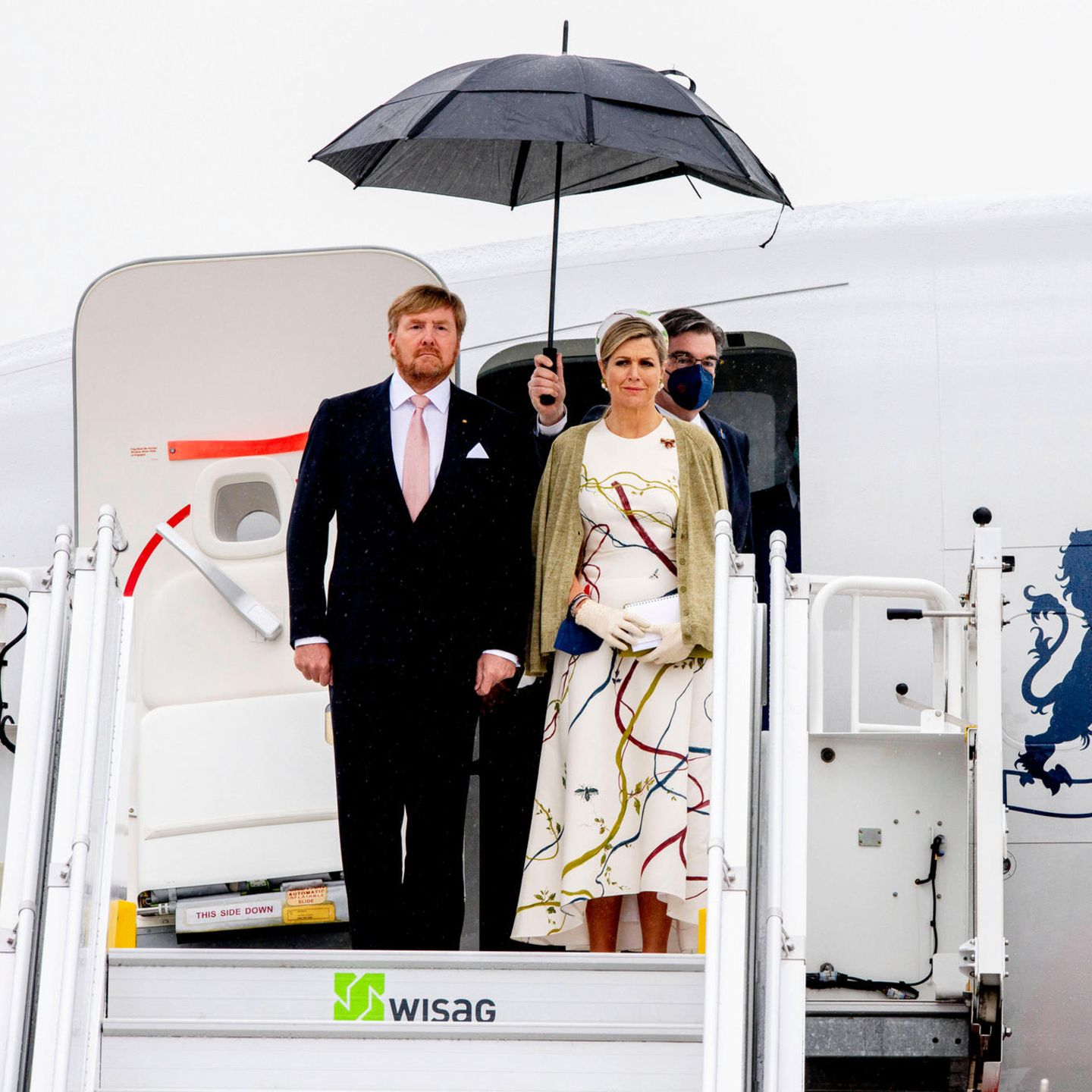 Zum Staatsbesuch von Königin Máxima und König Willem-Alexander zeigt sich Berlin nicht gerade von seiner sonnigen Seite. Máxima zeigt sich gewohnt stylisch in einem weißen Vokuhila-Kleid mit auffälligem Muster. Wer genauer hinsieht, erkennt, dass das Muster auch auf ihrem Haarreifen zu erkennen ist. Ein perfekt durchdachter Look... 